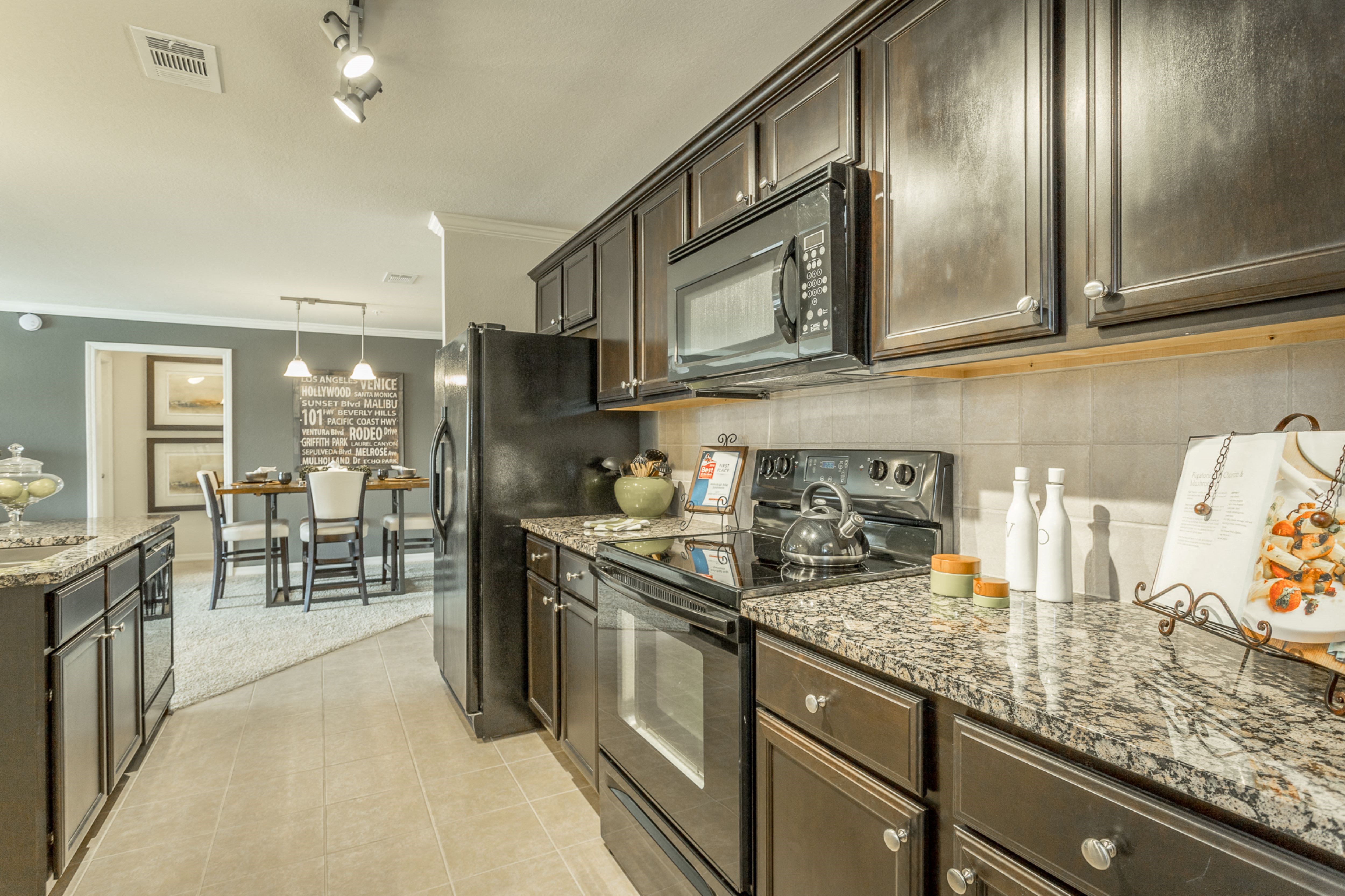 Beautiful kitchen with black energy efficient appliances and granite countertops at Amberleigh Ridge